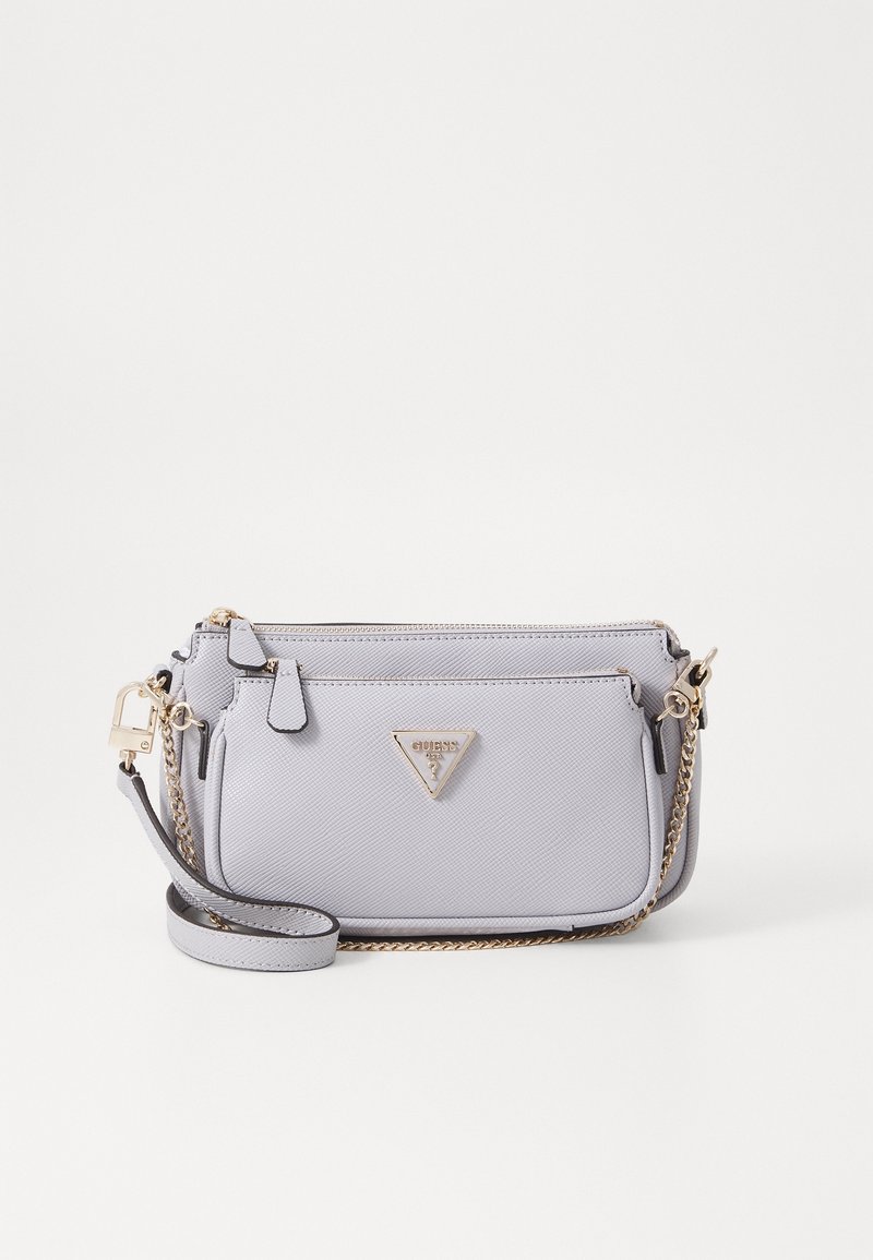 Jasnoszara torebka nadgarstkowa Guess z paskiem na łańcuszku w złotym odcieniu, przednią kieszenią na suwak oraz trójkątną plakietką z logo na teksturowanej skórze.