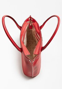 Rød lædertaske med to lange håndtag, lynlåslukning og beige mønstret indvendig foret med flere rum.