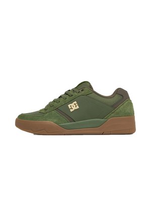 Lavtop grøn sneaker med brun sål, ruskind og mesh paneler, snørelukning foran og guld DC-logo på siden.