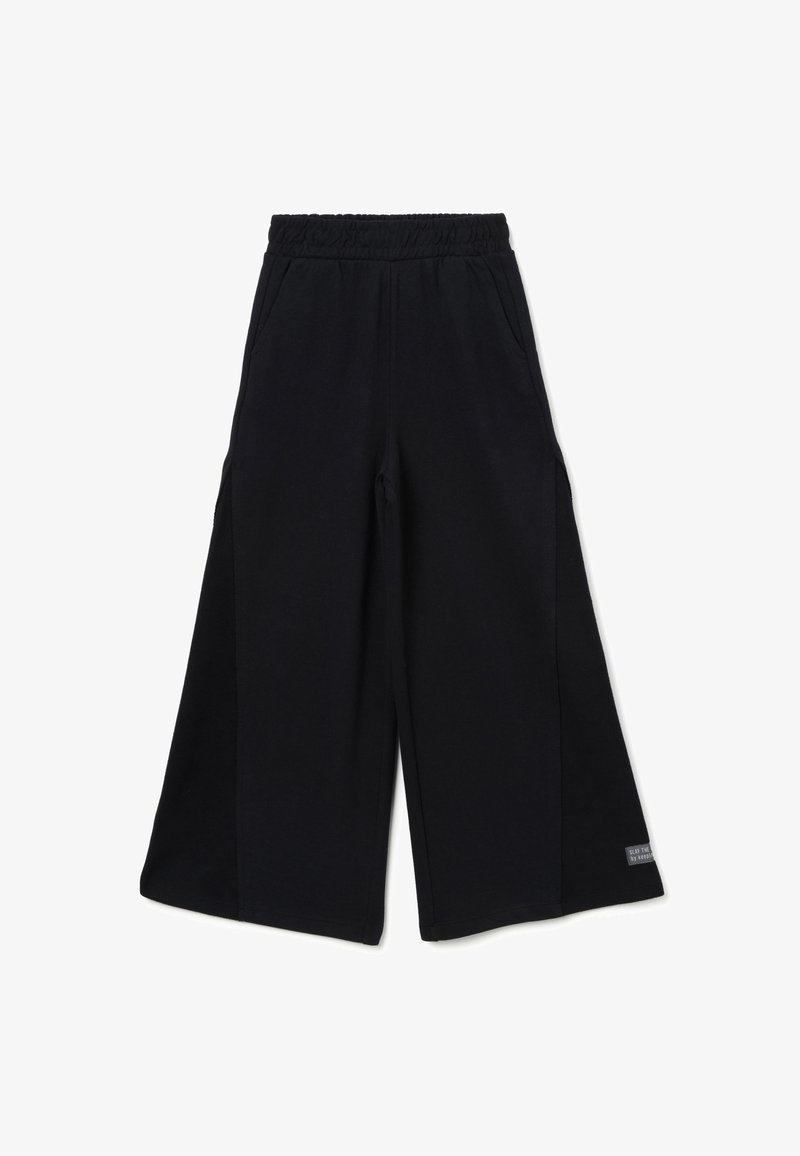 Pantalons larges noirs en tissu doux, dotés d'une taille élastique et de poches latérales, avec une petite étiquette logo sur le bas de la jambe.