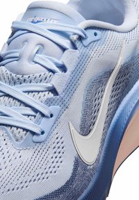 Ανοιχτό μπλε παπούτσι για τρέξιμο Nike Pegasus με λευκό λογότυπο Swoosh, μπλε κορδόνια και λεπτομέρεια από πλέγμα στο επάνω μέρος που δείχνει υφή και οπές αερισμού.
