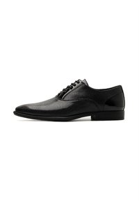 Scarpa da uomo nera con texture superiore perforata, punta affusolata e dettagli lucidi sul tallone. Dotata di lacci tradizionali.