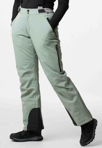 Hellgrüne Skihosen mit glatter Textur, zwei Seitentaschen, einer Reißverschlusstasche am Oberschenkel und verstärkten schwarzen Bündchen. Enthält verstellbare Träger.