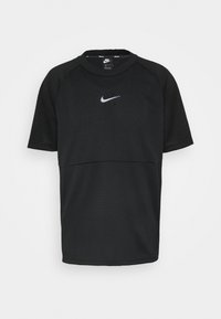 Svart Nike träningsskjorta gjord av nätmaterial, med rund hals, korta ärmar och en reflekterande logotyp på bröstet.