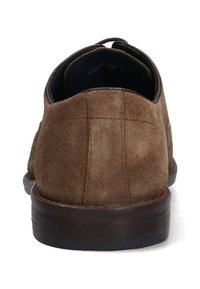 Bruine suède schoen met een ronde hak, platte zool en contrasterende stiksels. Achteraanzicht benadrukt de gladde textuur en de gebogen kraag.