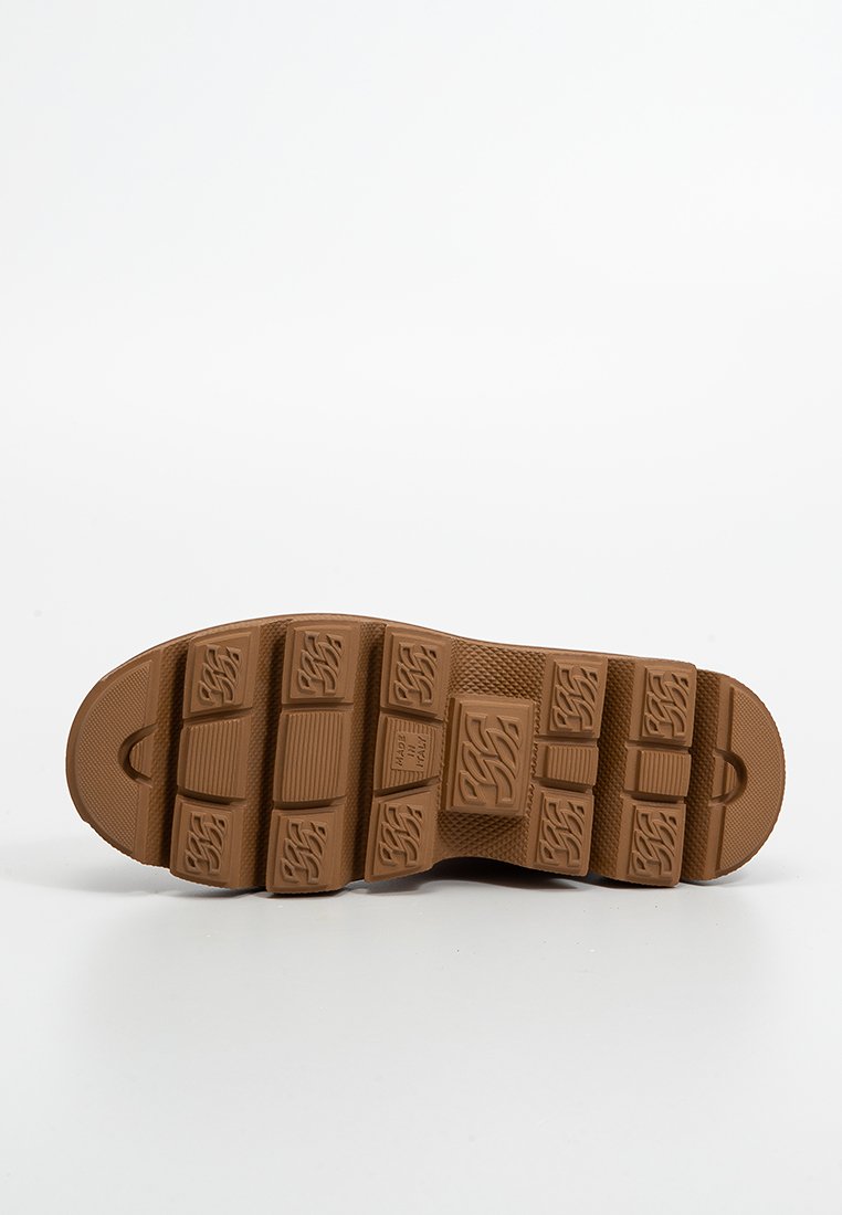 Brown rubber shoe sole with deep treads and patterned grooves, isolated on a white background.