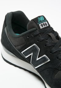 Sneaker New Balance 996 nera con parte superiore in suede e mesh, suola intermedia bianca e logo teal sulla lingua e sul lato.
