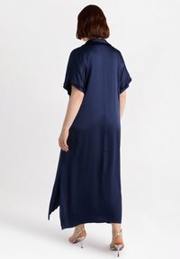 Navy blue satin dress with short sleeves, a collared neck, and side slits. Features a smooth, glossy texture and falls to mid-calf length.