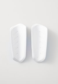 White plastic shoe inserts with a smooth texture, featuring contoured shapes and side grooves, labeled "L" and "R" for left and right.