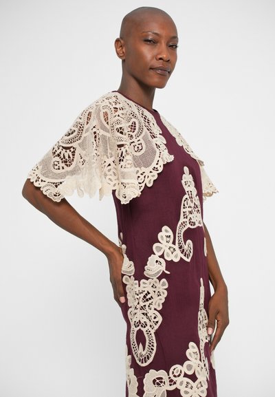 Vestido bordo com elaborados detalhes em renda creme, apresentando mangas curtas em renda e padrões florais, o tecido tem uma textura suave.