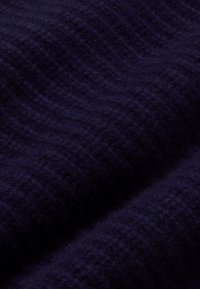 Navyblauw gebreide stof met een gestructureerd oppervlak, met een geribd patroon. Het materiaal lijkt zacht en dicht.