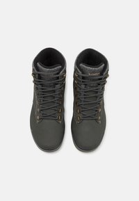 Grijze wandelschoenen hebben een glad leren buitenkant, een gestructureerde grijze stoffen kraag, metalen veterogen en contrasterende veters.