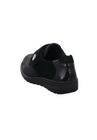 Black shoe featuring a textured fabric front, smooth patent back, and adjustable strap with a metallic accent. Durable rubber sole.