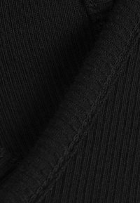 Musta, ryhmitelty kangas, jossa on hienot pystysuuntaiset viivat ja sileä rakenne. Sisältää sauman yksityiskohtia, jotka korostavat materiaalin joustavuutta.