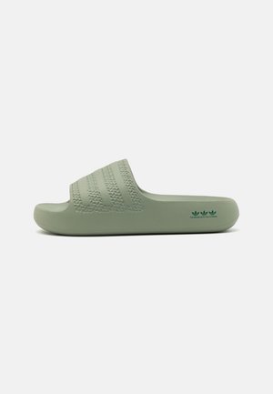Sandale slide vert clair unique avec un design texturé à trois bandes sur la bride et un logo avec texte sur le côté du talon.
