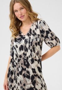 Leopard print dress in shades of beige, black, and gray; features a V-neckline and short puff sleeves; smooth fabric texture.