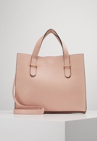 Světle růžová kožená taška přes rameno s dvěma horními uchy, odnímatelným ramenním popruhem a zlatými detaily. Hladký povrch s čistými okraji.