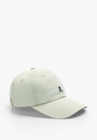 Light green baseball cap made of soft fabric, featuring a black skull logo on the front, with stitching details and an adjustable strap at the back.