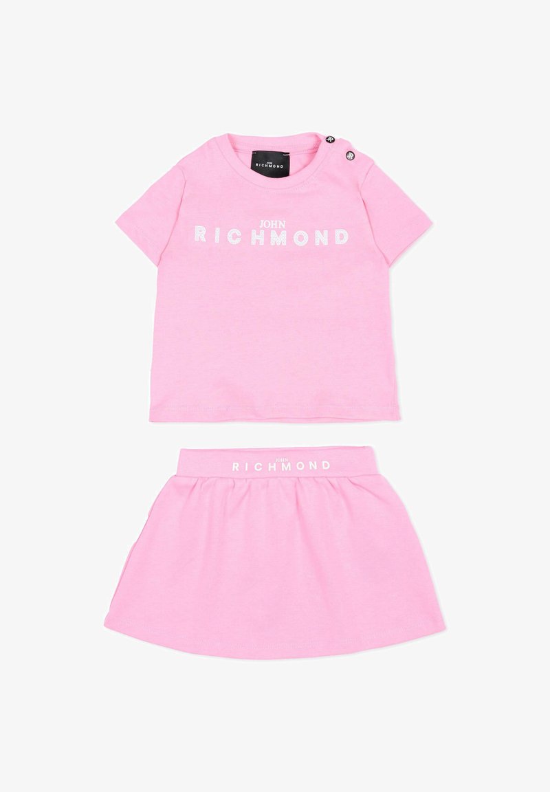 Tenue rose pour tout-petit avec chemise à manches courtes et jupe, les deux arborant le logo blanc "John Richmond" et des boutons-pression aux épaules de la chemise.