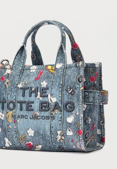 Denim totebag med fargerike små trykk, svart brodert "THE TOTE BAG MARC JACOBS" tekst, og doble håndtak.