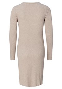 Beige lange mouw jurk met een getailleerd ontwerp, geribbelde textuur en een ronde halslijn. Valt tot halverwege de kuit met een eenvoudige, effen kleur.