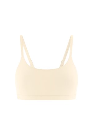 Bralette beige sans couture avec bretelles fines réglables, large bande sous la poitrine et tissu lisse et extensible.