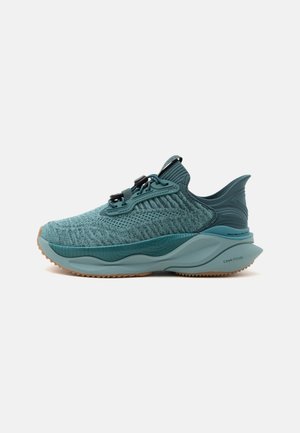 Zapatilla deportiva de punto color teal con suela texturizada, cordones elásticos ajustables y talón acolchado para correr o uso casual.