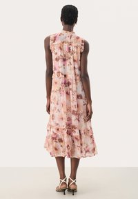 Rochie midi florală dintr-un material transparent, cu nuanțe de roz și maro, cu umeri volan și tiv în straturi. Accentuată cu detalii delicate.
