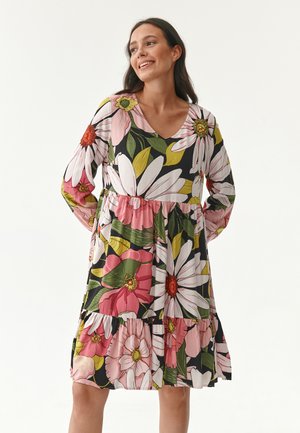 Abito floreale con scollatura a V e maniche lunghe. Presenta grandi fiori rosa, bianchi e verdi su uno sfondo nero. Orlo a balze a strati.