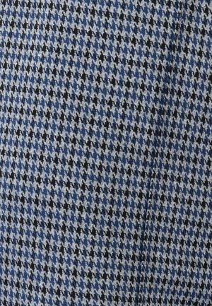 Motivo in tessuto pied-de-poule blu, nero e bianco con una leggera texture e una piega sottile visibile nel tessuto.