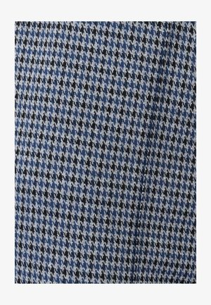 Patrón de tela pata de gallo en azul, negro y blanco con una ligera textura y un pliegue sutil visible en el textil.