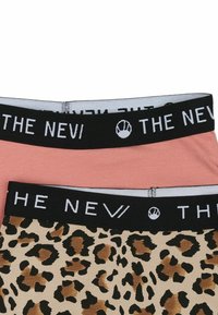 Dve páry dámskeho spodného prádla: jedny v jednotnom ružovom a jedny s béžovým leopardím vzorom, obe s čiernymi elastickými páskami s textom "THE NEV".