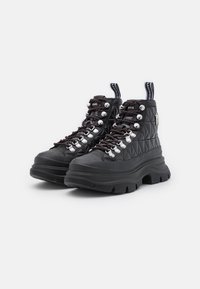 Botas de senderismo de cuero negro acolchado con suelas gruesas y con tacos, ojales plateados, cordones negros con acentos rojos y lengüetas de tirón con la marca "Lagerfeld".