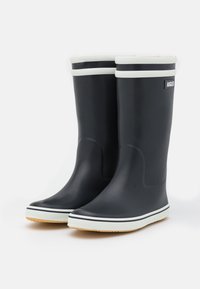 Mustat kumiset sateenkenkä, jossa on valkoinen reunus ylhäällä ja raidallinen yksityiskohta. Raskas pohja pitovoimaa varten ja kaareva muotoilu mukavuutta varten.