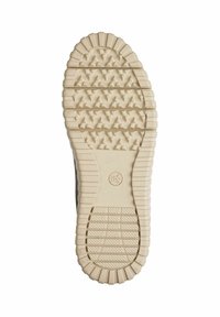 Semelle en caoutchouc avec un motif texturé et déchiqueté. Couleur crème clair avec un bord lisse et un logo circulaire près du centre.