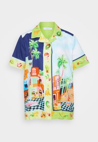 Camicia a maniche corte con bottoni, caratterizzata da un mix di pattern tropicali colorati, tra cui frutti, palme e edifici vivaci su uno sfondo chiaro.