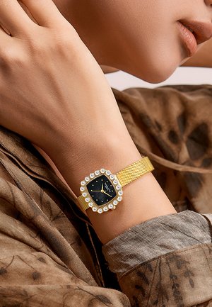 Reloj de pulsera de malla dorada con esfera negra, caja cuadrada y adornado con un anillo de piedras claras alrededor del bisel.