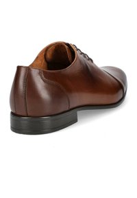 Brązowy skórzany but o eleganckim designie, okrągłym czubku i niskim czarnym obcasie. Posiada gładką teksturę i minimalne detale szewne.