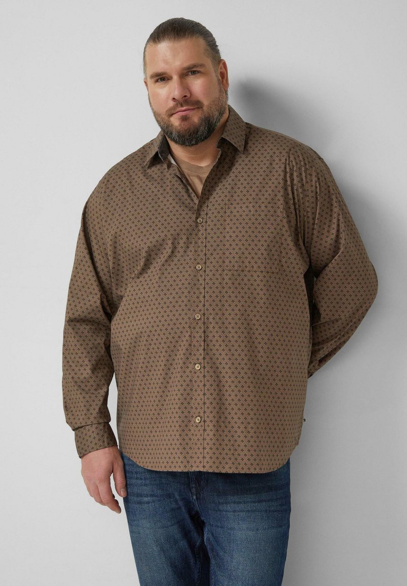 Brown button-up shirt with a small geometric pattern, long sleeves, and a classic collar; paired with blue jeans.