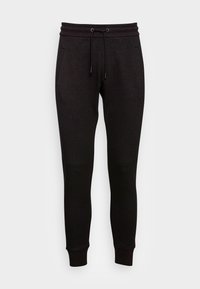 Svarta joggerbyxor i mjukt tyg, med dragsko i midjan, sidofickor och avslutade anklar med en slät yta.