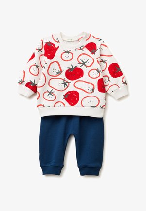 Biała bluzka z długim rękawem dla malucha z nadrukiem uśmiechniętych czerwonych pomidorów, zestawiona z granatowymi prążkowanymi spodniami.