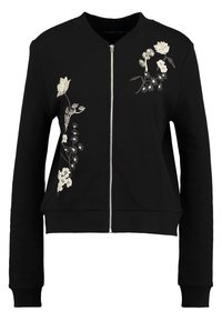 Sort zip-up sweatshirt med lange ærmer, ribbede manchetter og blomsterbroderi i hvide og lyse farver på fronten. Blød stofstruktur.