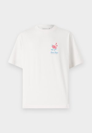 Fehér pamut póló kerek nyakkivágással és rövid ujjakkal, színes virágmintával és "Saint Tropez" felirattal a mellkasán.
