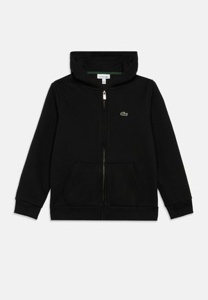 Black zip-up hoodie made of soft fabric, featuring a textured surface, two front pockets, and a small green embroidered crocodile logo.