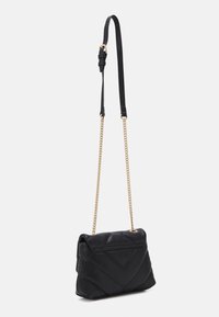 Černá prošívaná kožená kabelka přes rameno se zlatým řetízkem a nastavitelním černým koženým popruhem, nakloněná mírně doprava.