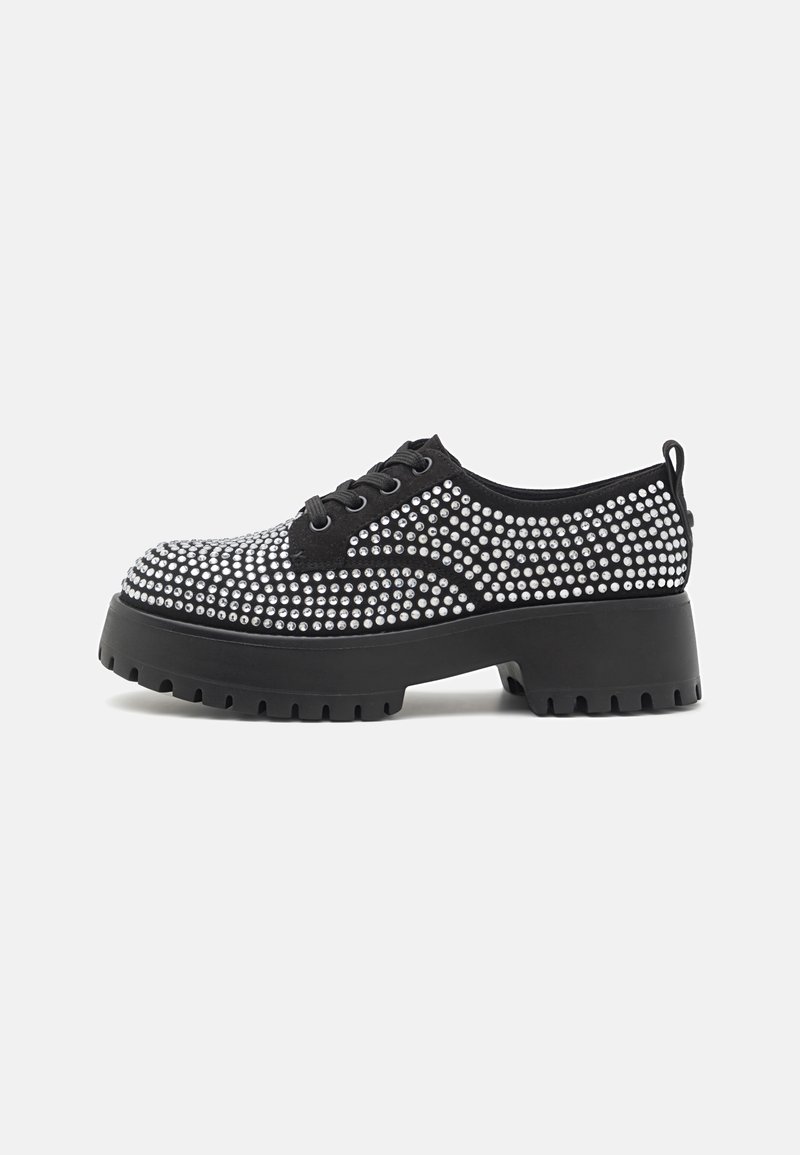 Chaussure plateforme noire épaisse avec lacets, décorée de clous argentés uniformément espacés couvrant la partie supérieure et les côtés.