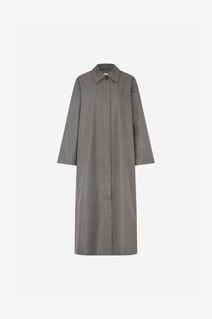 Grijze, knie-lange jas met een rechte snit, grote kraag en lange mouwen. Voorzien van twee zijzakken en een enkele knoopsluiting. Gladde textuur.