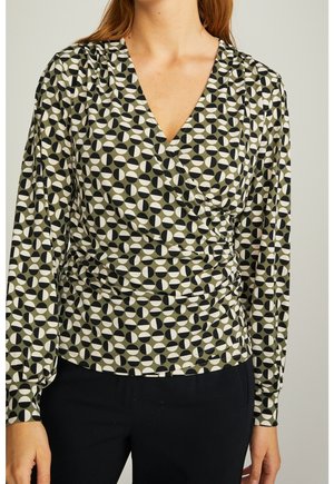 Kietaisupaita oliivinvihreästä kankaasta, jossa on geometrinen kuvio mustista, valkoisista ja beigen värisistä ympyröistä; pitkät hihat ja laskostetut yksityiskohdat.