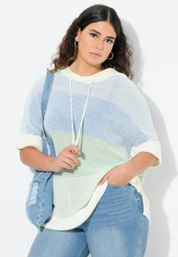 Lichtgewicht, gebreide, capuchonpullover in pastelblauw, groen en crème. Heeft korte mouwen en een gestructureerd ontwerp. Gecombineerd met denim.