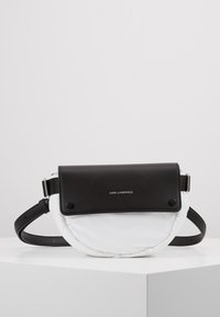 Borsa nera in pelle e tessuto imbottito bianco con forma arrotondata, tracolla regolabile e accessori in argento. Presenta il logo "KARL LAGERFELD".